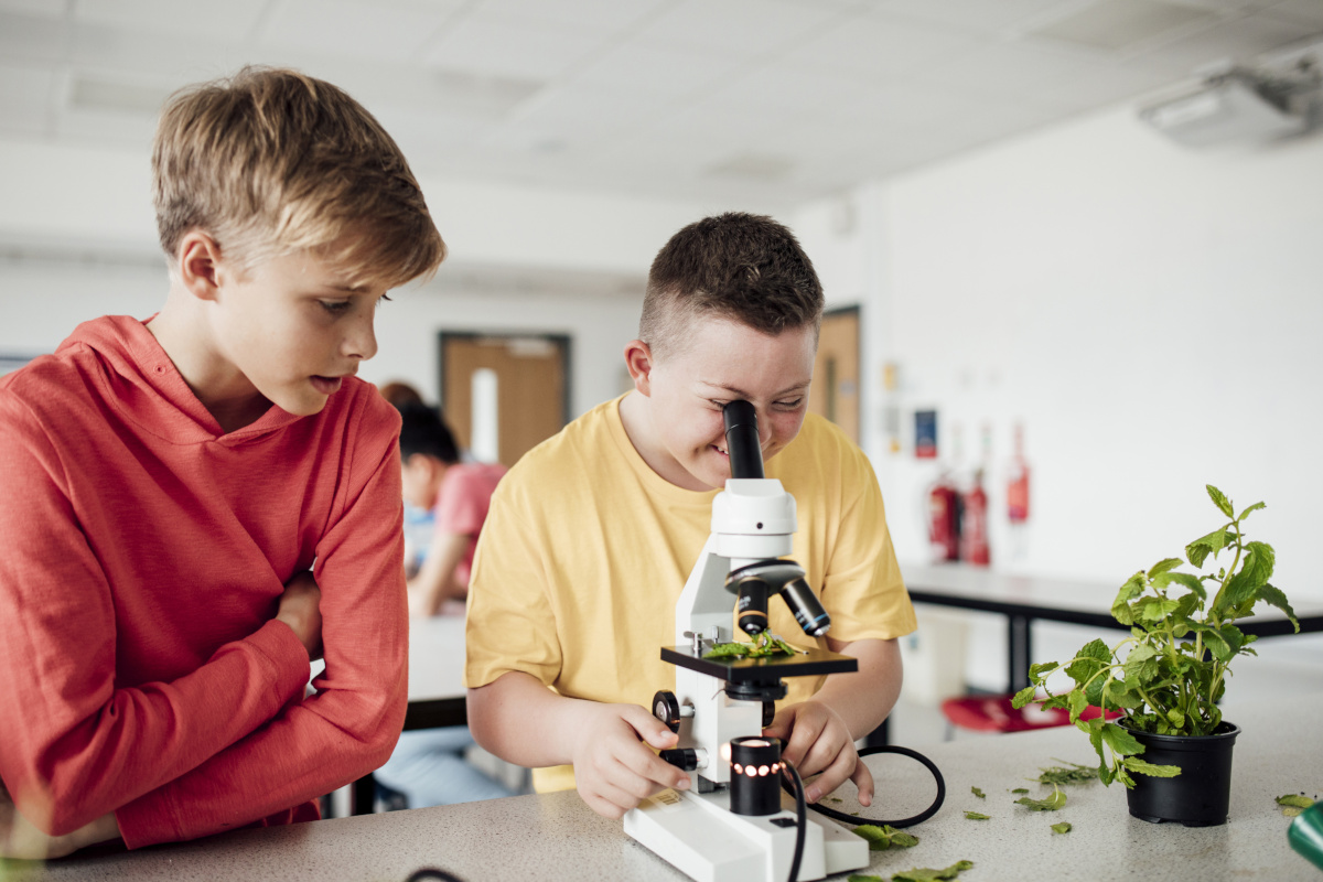 Smiling kid using microscope to study plant Smiling kid using microscope to study plant